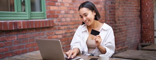 Ung voksen som vurderer kredittkort på laptop